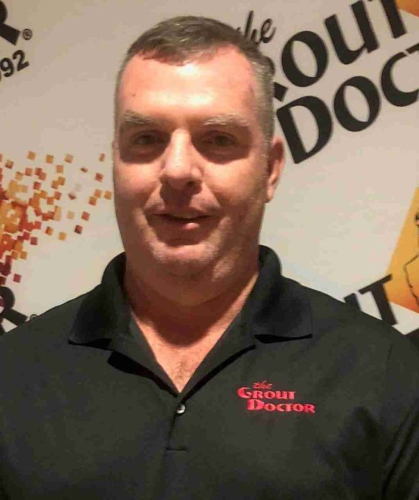 Man wearing Grout Doctor shirt, smiling.