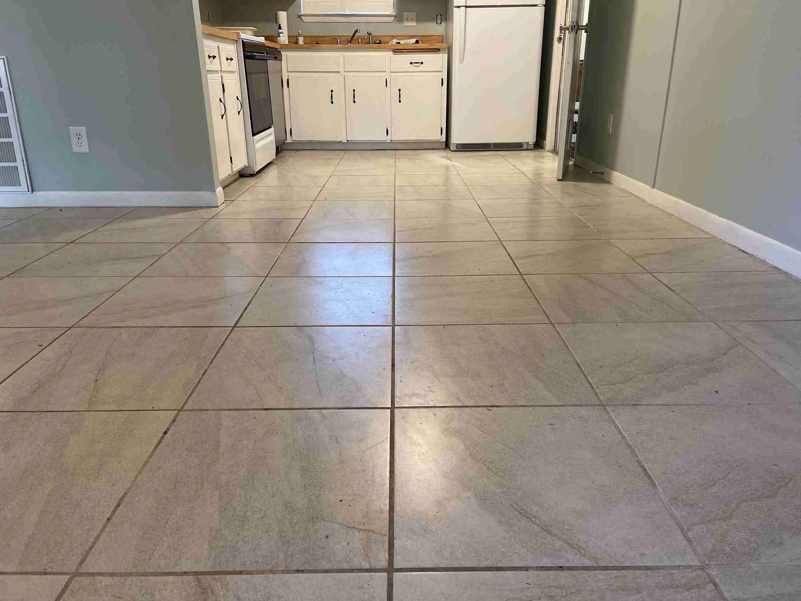 Spacious kitchen with tiled floor and appliances.