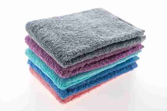 Stack of colorful towels on a white background.