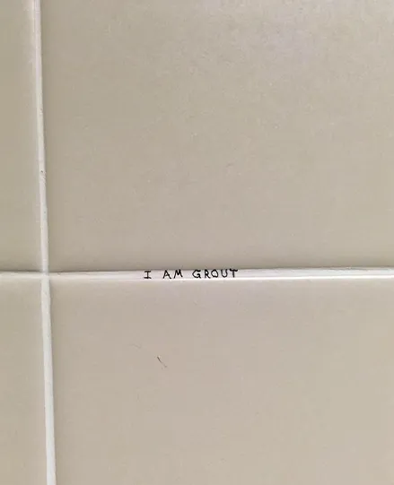 Text on tile reads 'I AM GROUT'.